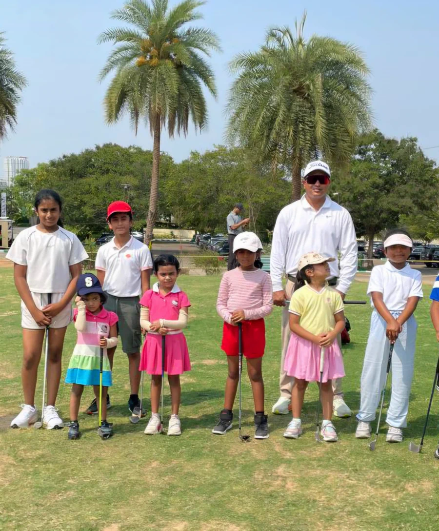 Junior golf students lined up with Coach Amit Khaitan during a group session